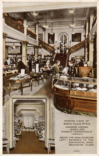 Shows the interior of a large and posh jewelry store with grand staircase in the background.
