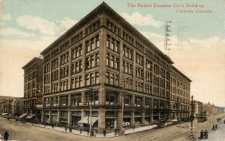 Colorized photograph of the corner of a six story department store built in the Chicago style.
