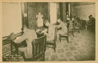 Black and white photograph of six men in military uniform sitting at wooden desk writing.