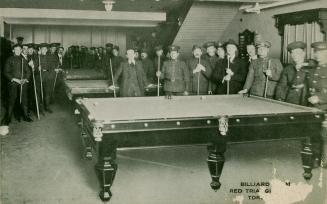 Black and white photograph of a group of men in uniforms and civilian cloths posing around pool ...