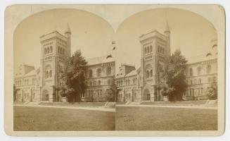 Pictures show a huge Romanesque revival, three story building with a central tower.