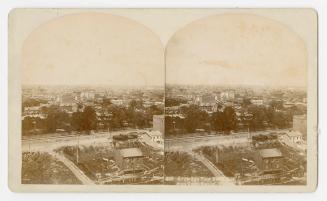 Pictures are taken from the air showing a large city on the other side of some railway tracks.