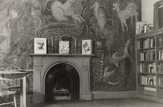 Picture of room with large mural on the wall and a fireplace with three books displayed on the  ...