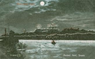 Picture of the lake at night with a full moon and lights on an amusement park in the background ...