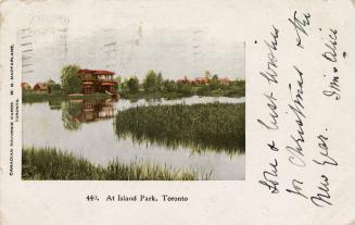 Picture of a cottage on a lagoon with grasses. 