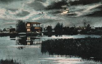 Picture of a lagoon on moonlit night with grasses and a large house and other buildings in the …