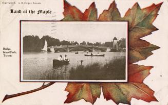 Boaters with bridge in background. Postcard background is a large maple leafe with caption "Lan…