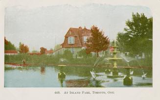 Lagoon with fountains and cottage in background.