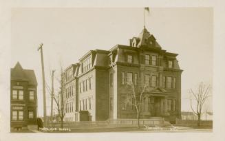 Black and white photograph of a large three story collegiate building.