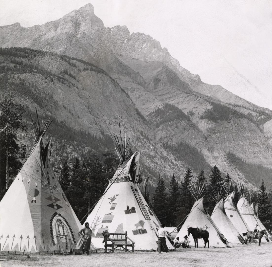 The line of tepees, the traditional house of the Plains Indians, in this case they Stoney tribe, make a pleasing sight at the foot of an Alberta mount(...)