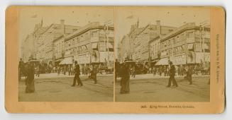 Pictures show crowds of people walking on a busy city street with very large buildings showing  ...