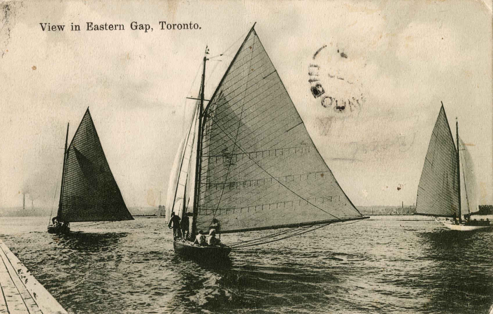 Black and white picture of three sailboats on open water.