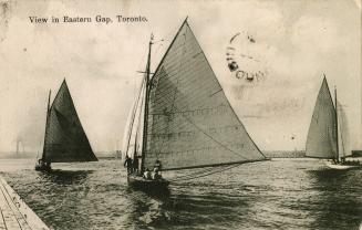 Black and white picture of three sailboats on open water.