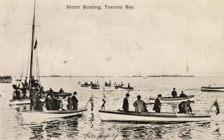 Black and white photograph of many people in boats on a large expanse of water.