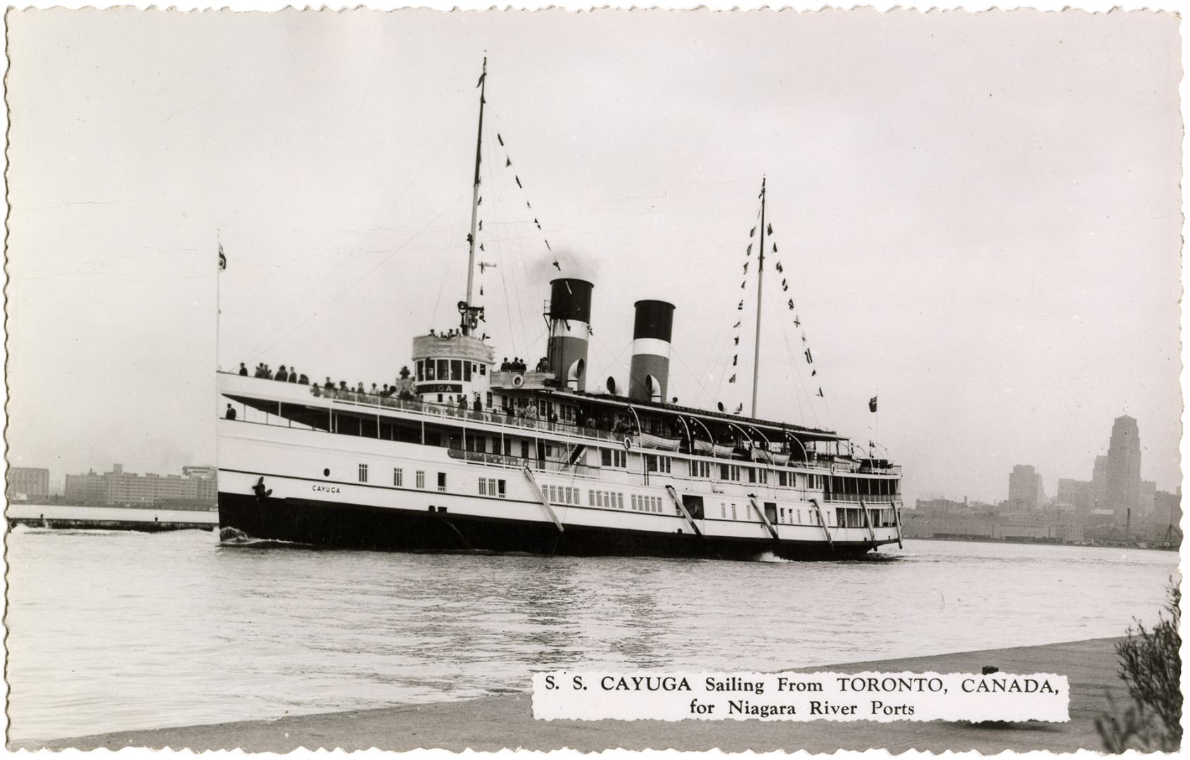 Black and white photograph of a steamship on a narrow body of water.