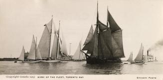 Black and white photograph of many sailboats on open water.