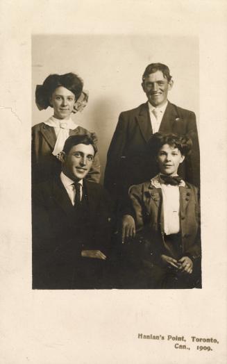 Black and white studio portrait of a mother, father and two adult children.