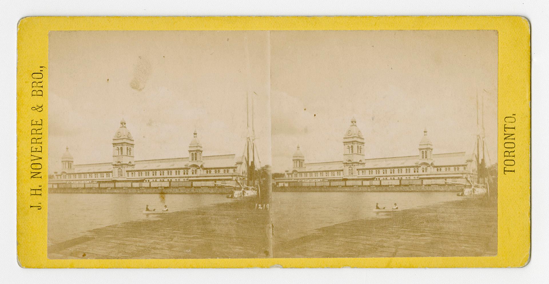 Pictures show a long low-rise public building with three towers beside a body of water.