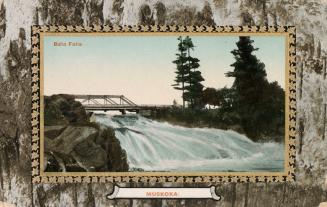 Colorized photograph of a waterfalls flowing over a rock with a bridge running across it. Pictu ...