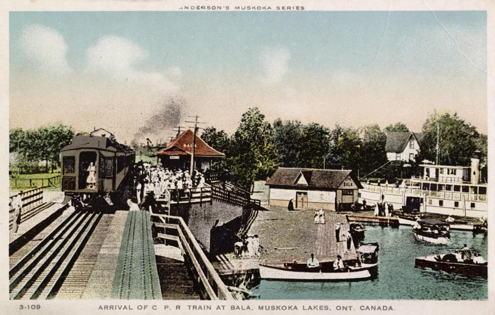 Picture of a train arriving at a station next to a wharf with boats