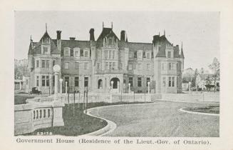 A photograph of a large house, designed in Second Empire style. The house is three stories tall ...