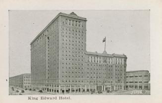A photograph of a large L-shaped hotel. The left side of the building is approximately twice as ...