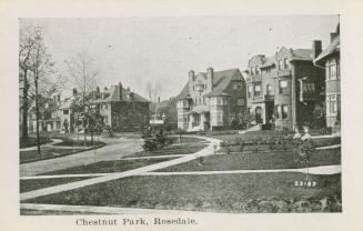 A photograph of an affluent residential area, with several large houses with lawns in front and ...