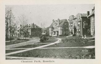 A photograph of an affluent residential area, with several large houses with lawns in front and…