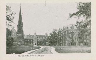 A photograph of a large college building, with a path leading to the main entrance. There is a  ...