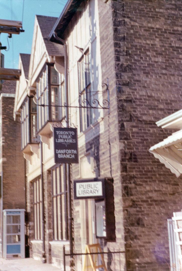 Picture of side view of library building with two library signs. 
