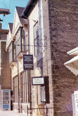 Picture of side view of library building with two library signs. 