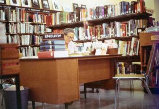 Picture of a librarian at an inquiry desk. 