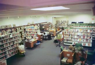 Picture of room in library with shelves and study carrels. 