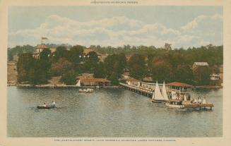 Boats on a lake with a large pier and grand hotel in the background