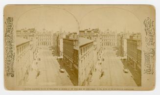 Pictures shoe a four story public building at the top of a city street with tall buildings on e…