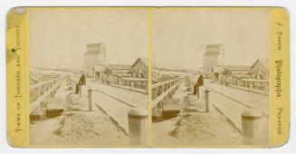 Pictures show a man sitting on a post along side a road with a freight elevator and a body of w ...