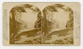 Pictures show a large collegiate building off in the distance. Man standing on a grassy hill be ...