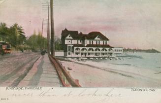 Picture of beach and boardwalk with building in the background and radial rail car. 