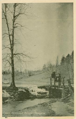 Black and white picture of road bridge running over a narrow creek in wintertime.