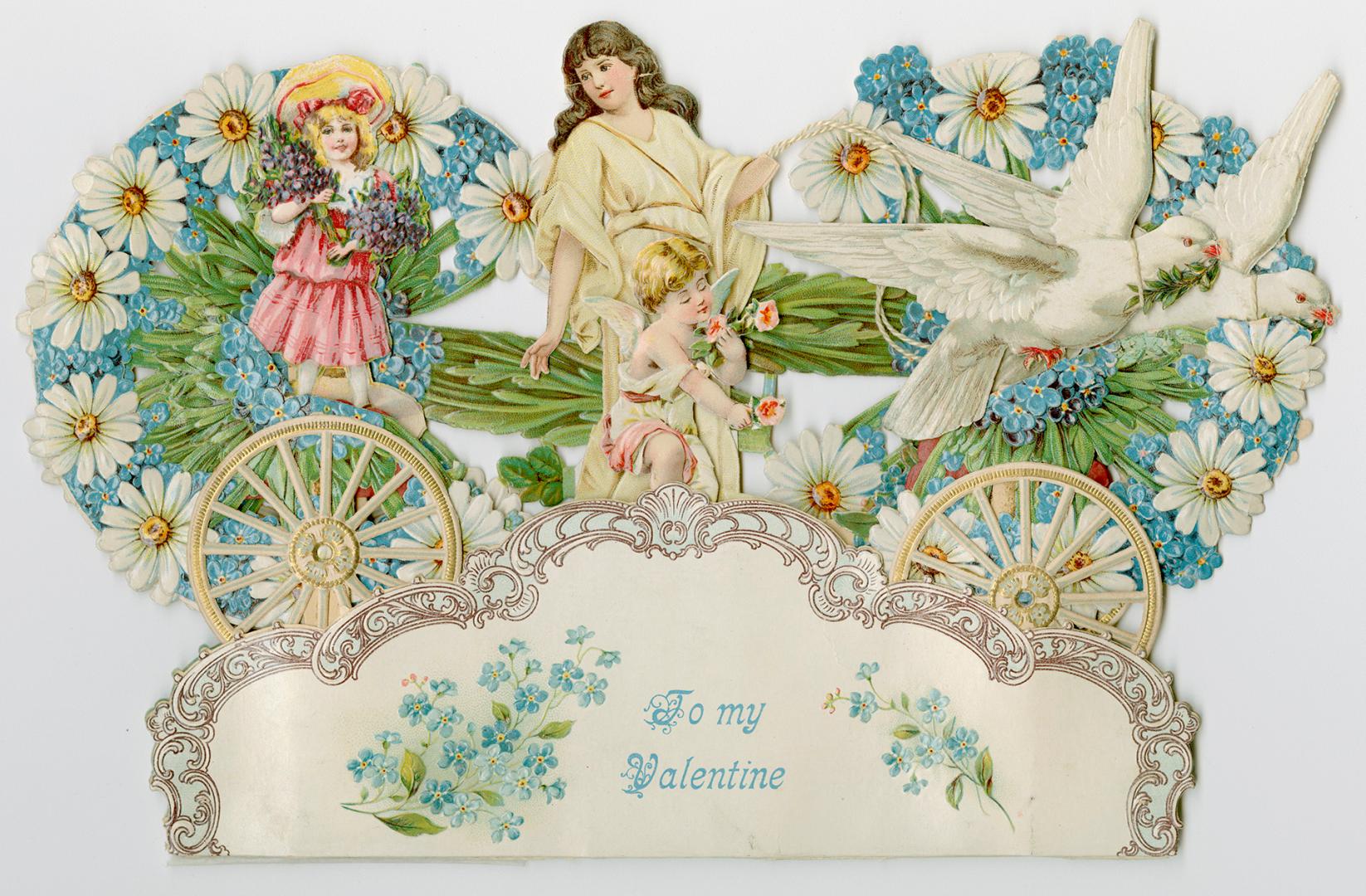 A lady in cream coloured robes drives a carriage made of blue and white flowers. The carriage i ...