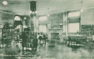 Picture of room in a library with tables, books and fireplace. 