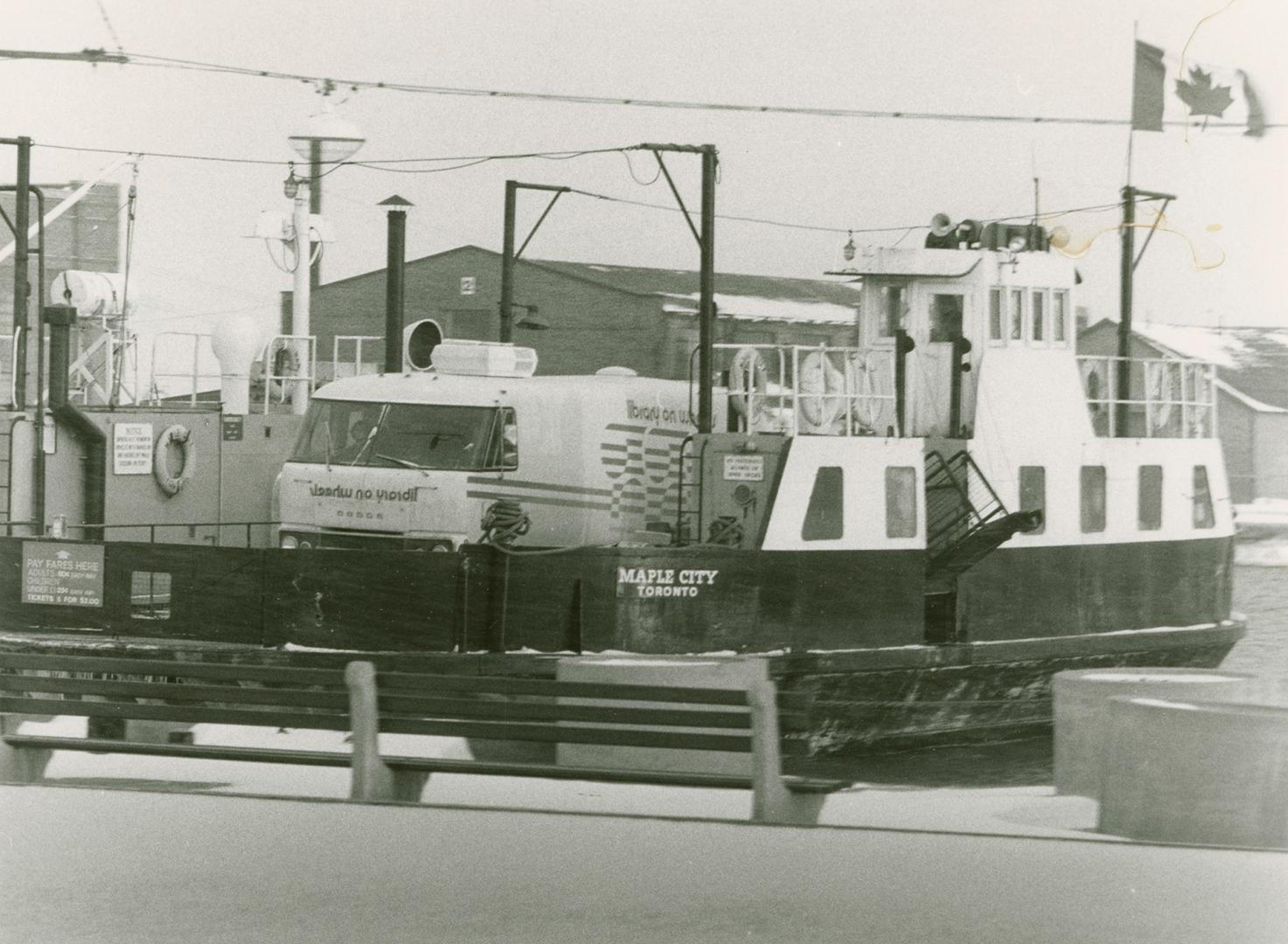 Picture of a ferry with a bookmobile on it at a ferry dock. 
