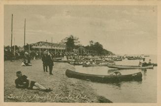 Picture of man lying on the beach in foreground with other people on the beach in background an ...