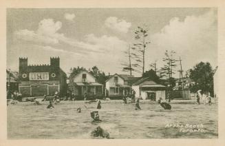 Black and white picture of people swimming in water with arcade buildings on the shoreline.