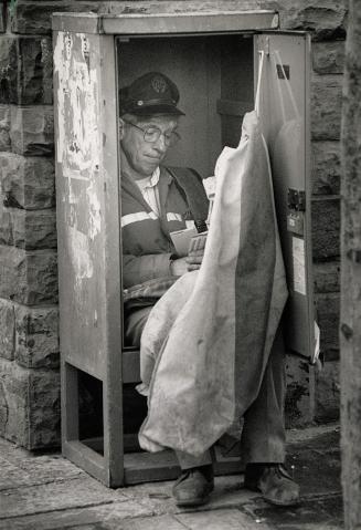Just Sittin' in the rain, Letter carrier Harold Campbell retreats into a mall receptacle on Younge St