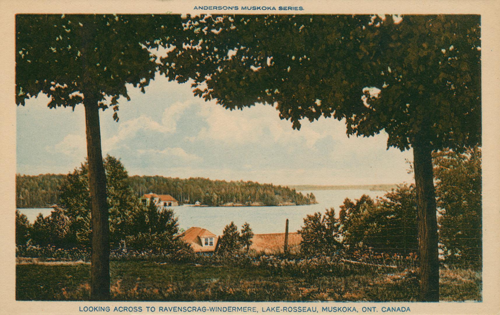 A lake surrounded by woods with buildings on either side.