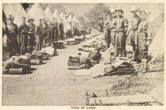 Sepia toned picture of a group of airmen lined up in front of tents in a military camp.