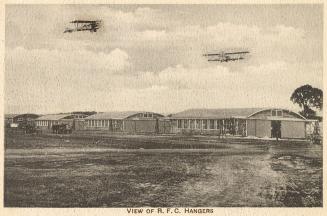 Sepia toned picture of a line of tents in an airfield. Planes are flying overhead.
