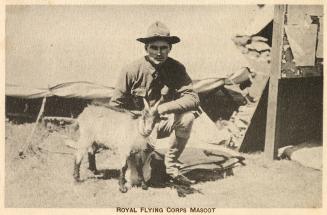 Sepia tone picture of a cadet kneeling beside a miniature goat.