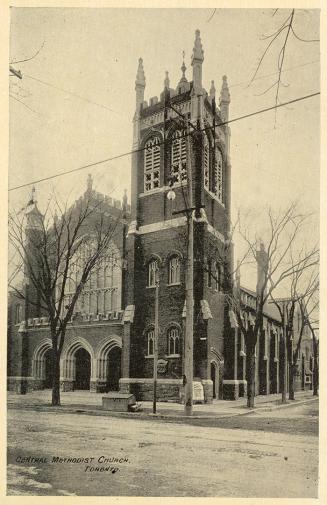 Picture of large church building on a corner with square tower on right.